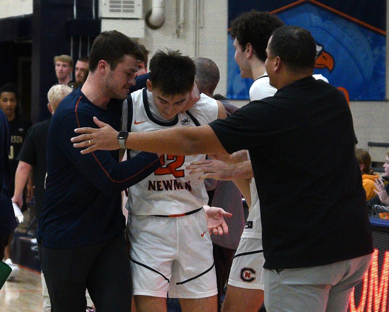Carson-Newman basketball players huddle around each other after a hard-fought victory. 